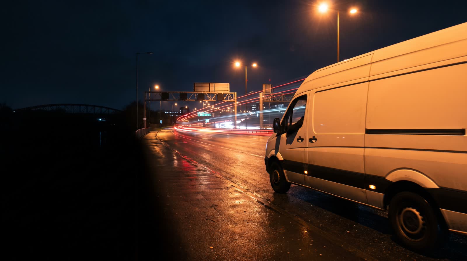A white van on a city ring road at night